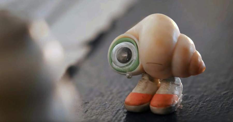 Marcel the Shell With Shoes On | มาร์เซล หอยจิ๋วกับรองเท้าคู่ใจ (2021) / หอยทากตัวเล็กสวมรองเท้าสีส้ม ร้องไห้ด้วยความเศร้า โดยมีตาข้างหนึ่งทำจากเปลือกหอยสีเขียว